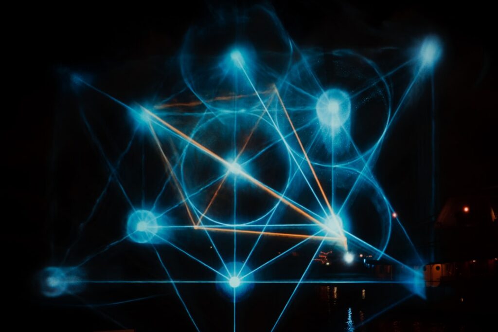 Abstract, modern image showing a complex network of glowing blue and purple lines against a dark background, representing ...