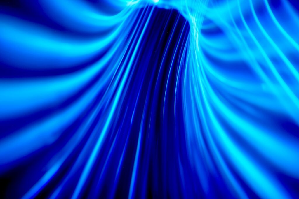 Abstract visualization of glowing blue light trails moving rapidly, representing the concept of zero-latency data flow and...