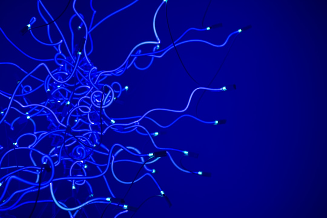 A complex tangle of glowing fiber optic cables on a dark, modern background, representing the chaos of disconnected AI tools and systems.