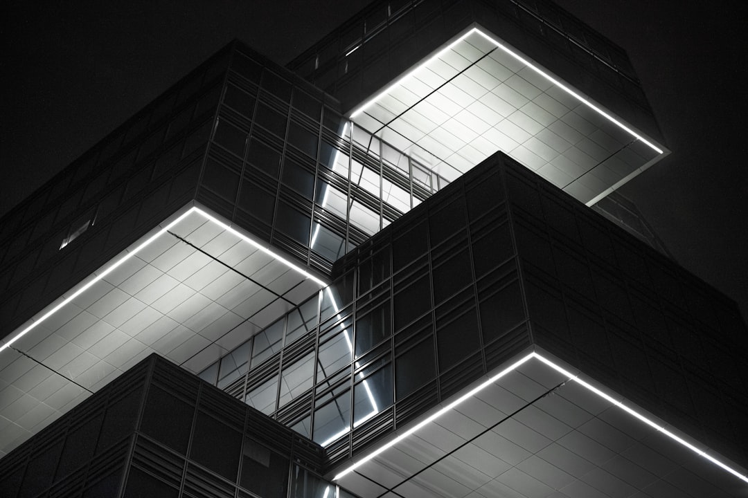 A modern, abstract image of glowing blue and white lines forming a complex architectural structure on a dark background, representing the architecture of a cognitive supply chain.