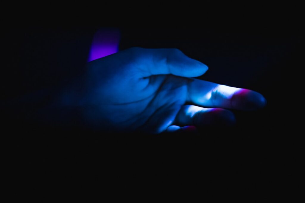 Person's hands manipulating a complex, glowing blue holographic interface in a dark, modern setting, symbolizing the creat...
