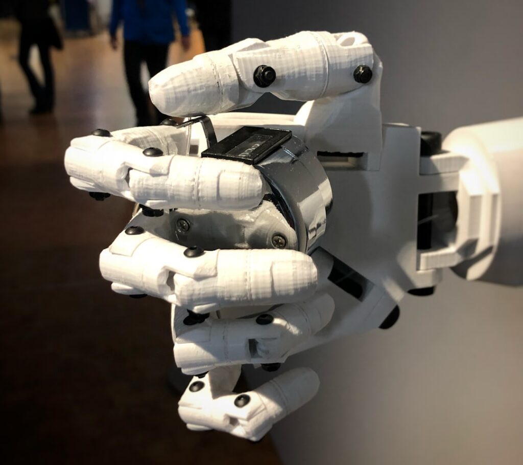 Close-up of a human hand making contact with a robotic or android hand, set against a clean, minimalist background to symb...