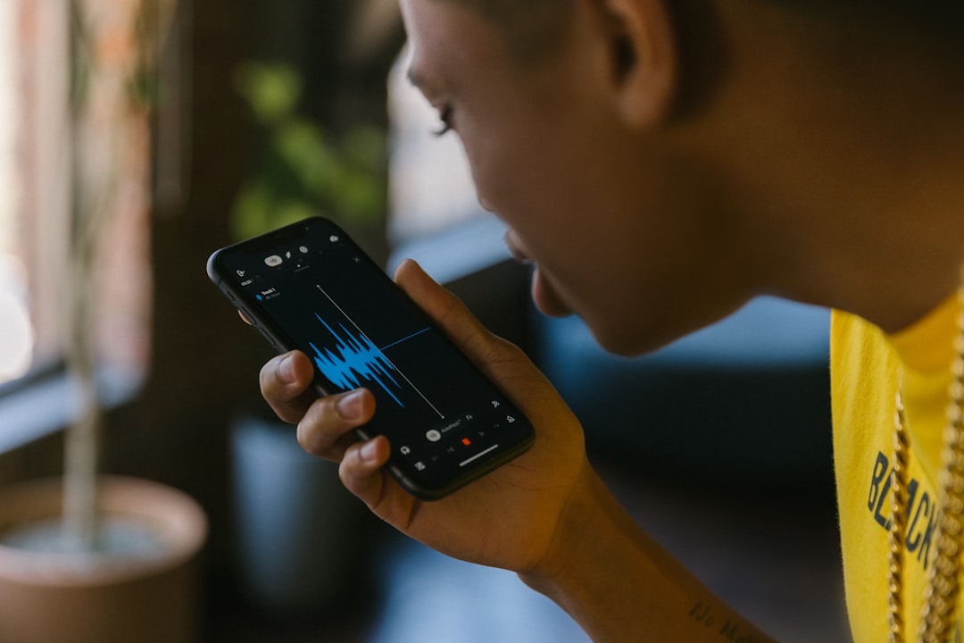 A person's hands are seen interacting with a holographic or futuristic digital interface displaying audio waveforms, symbolizing the building of a sonic brand with AI.