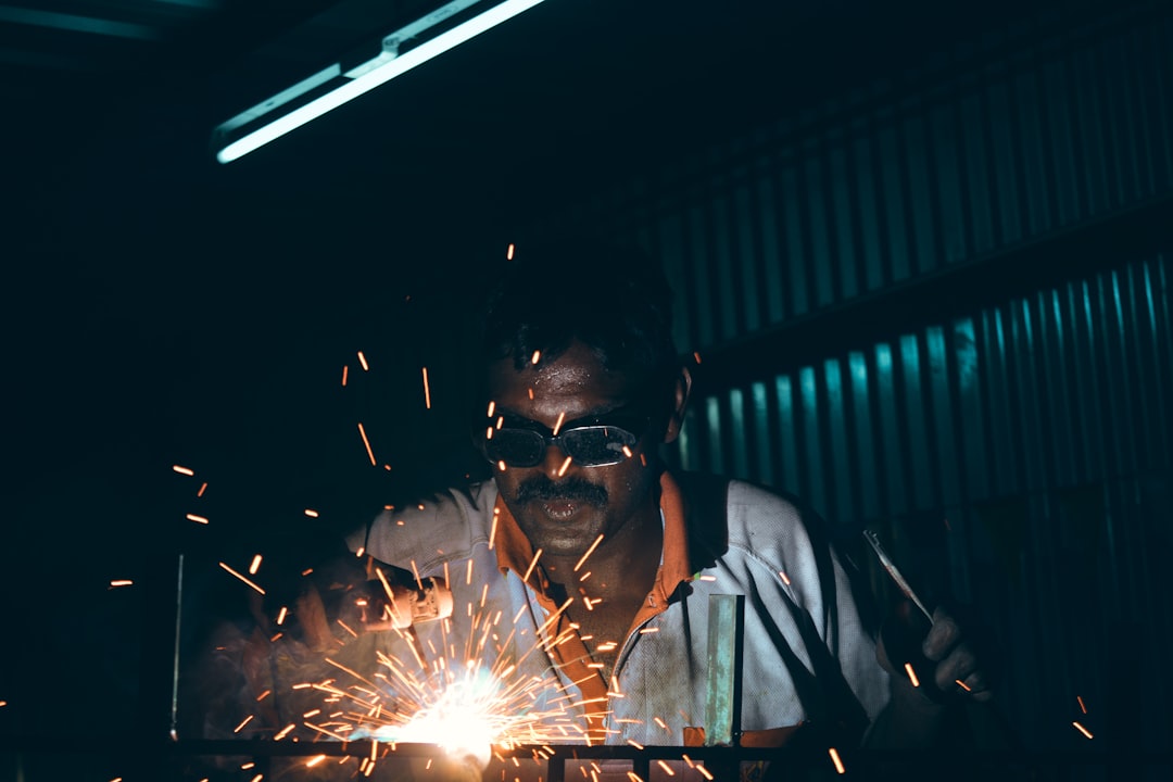 A powerful close-up of a blacksmith's hammer striking a piece of glowing hot metal on an anvil, with bright sparks flying, representing the process of strengthening through stress and pressure.
