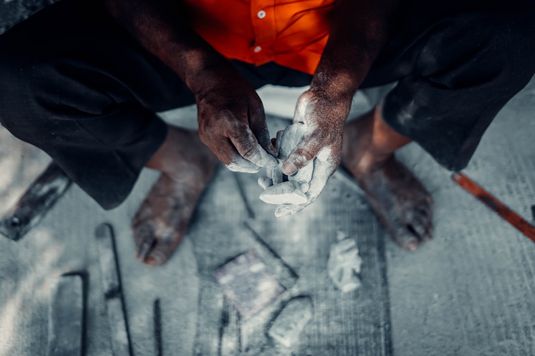 A sculptor's hands precisely carving away excess material from a block of white marble, symbolizing the process of refining a knowledge base for accuracy.