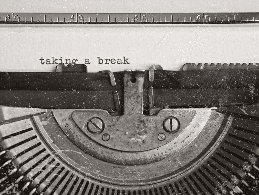A classic black typewriter sits next to a sleek, glowing tablet on a minimalist surface, illustrating the shift from traditional methods to new AI technology.