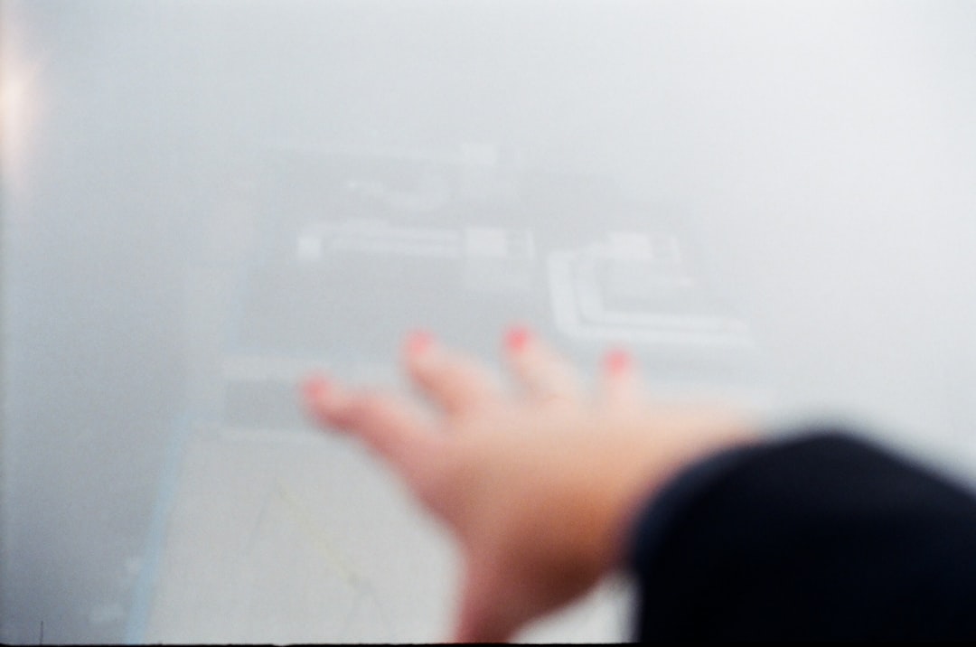 Close-up on hands interacting with a futuristic, glowing holographic interface, illustrating the proactive management of brand data for AI systems.