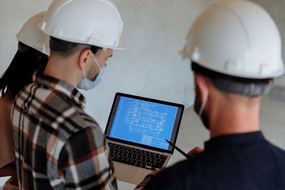 An old, faded blueprint is spread out on a dark, modern work surface, representing an outdated business strategy in the new era of AI.