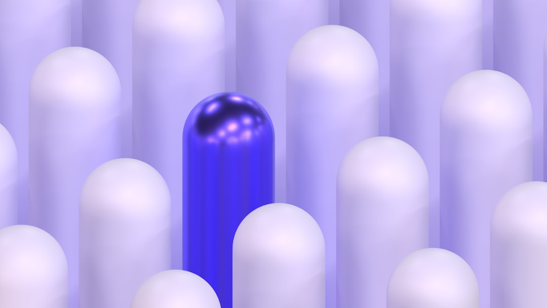 A single brightly colored sphere stands out distinctly in a large group of identical, monochrome spheres, representing brand uniqueness in a sea of sameness.