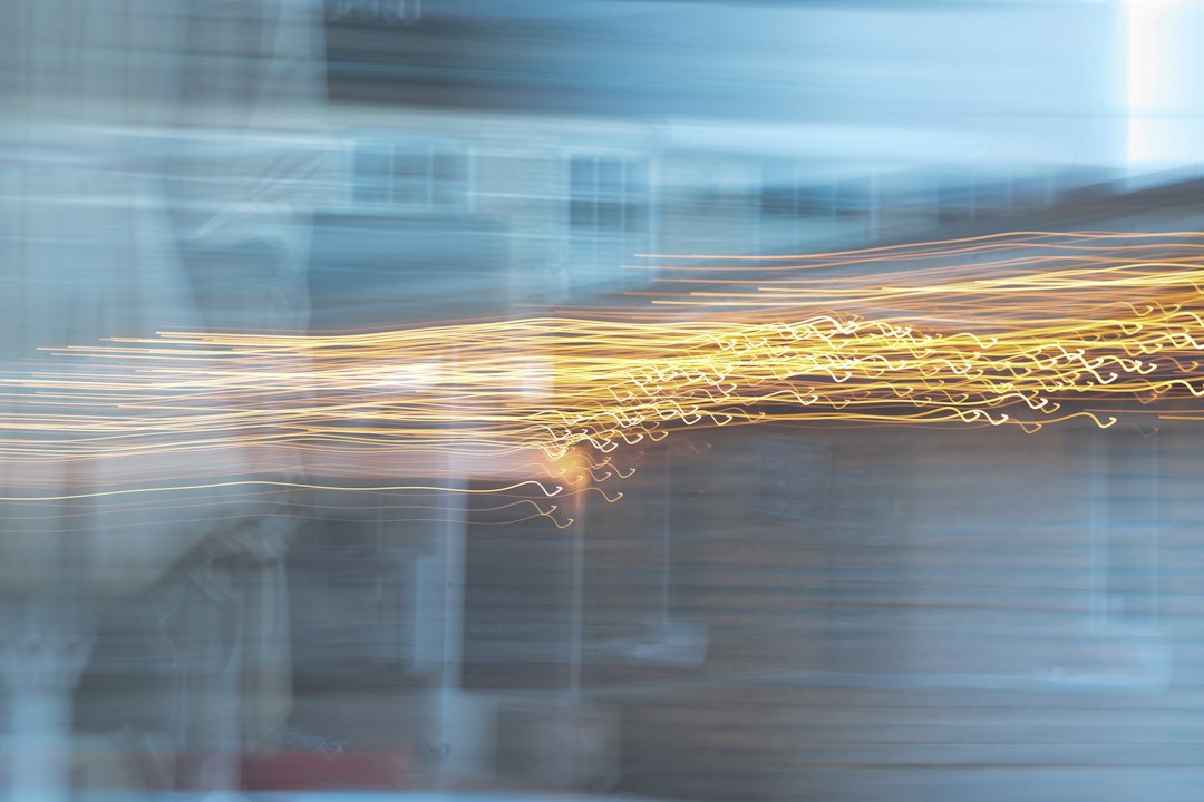 A modern abstract image of vibrant, flowing light trails on a dark background, symbolizing the process of capturing and scaling intuitive knowledge with AI.