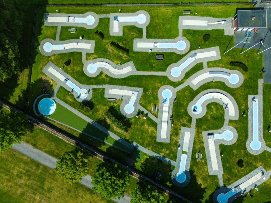 An aerial top-down view of a complex and minimalist concrete maze with bright, clean lighting, representing the architectural challenges of scaling AI initiatives.