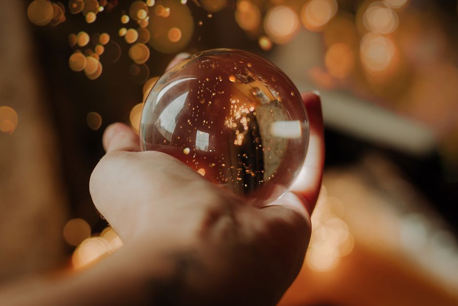 A close-up of a human hand gently touching a calm, glowing orb of light, illustrating the concept of human-centered AI and trust in technology.