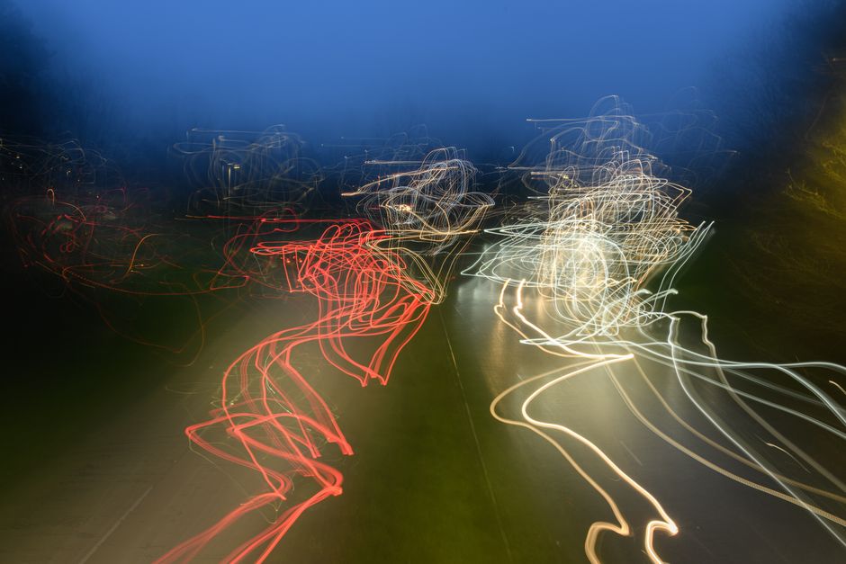 A long-exposure photograph of blurred light trails coming to a single, sharp point of focus, representing clarity emerging from the chaos of real-time data.